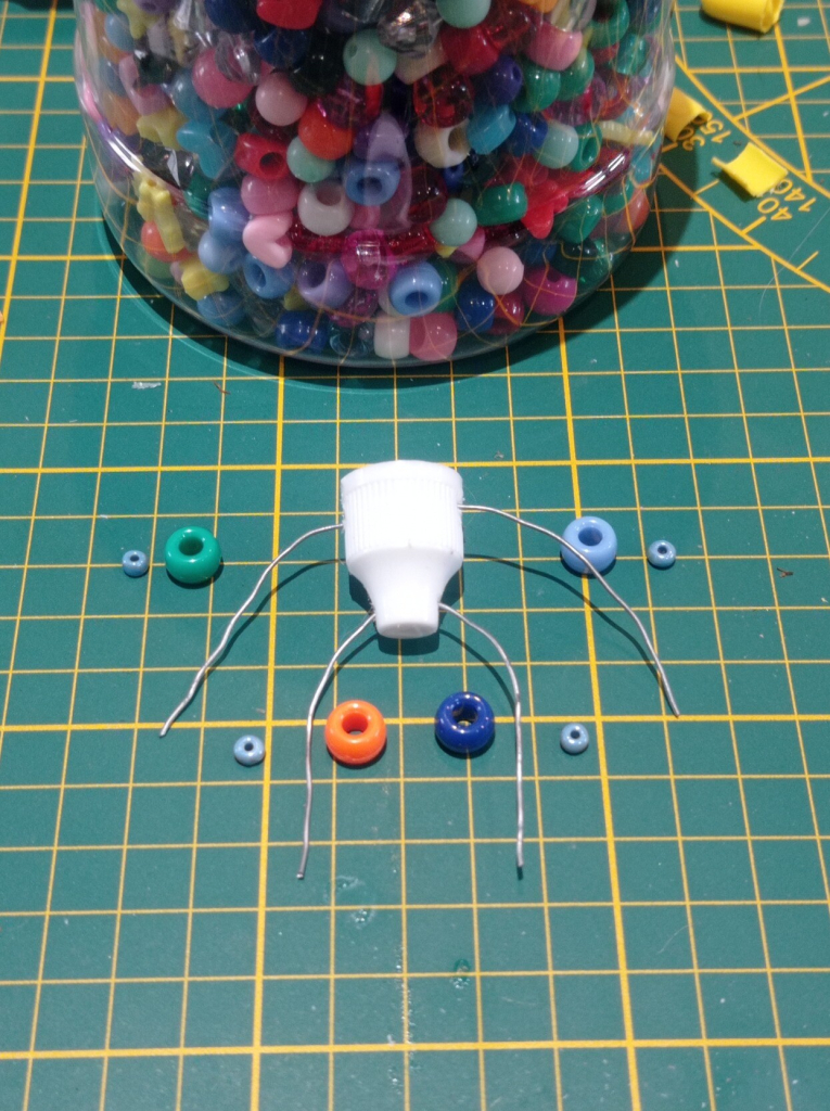 The body with a wire placed on top and bottom to create legs and arms and beads placed on the sides.