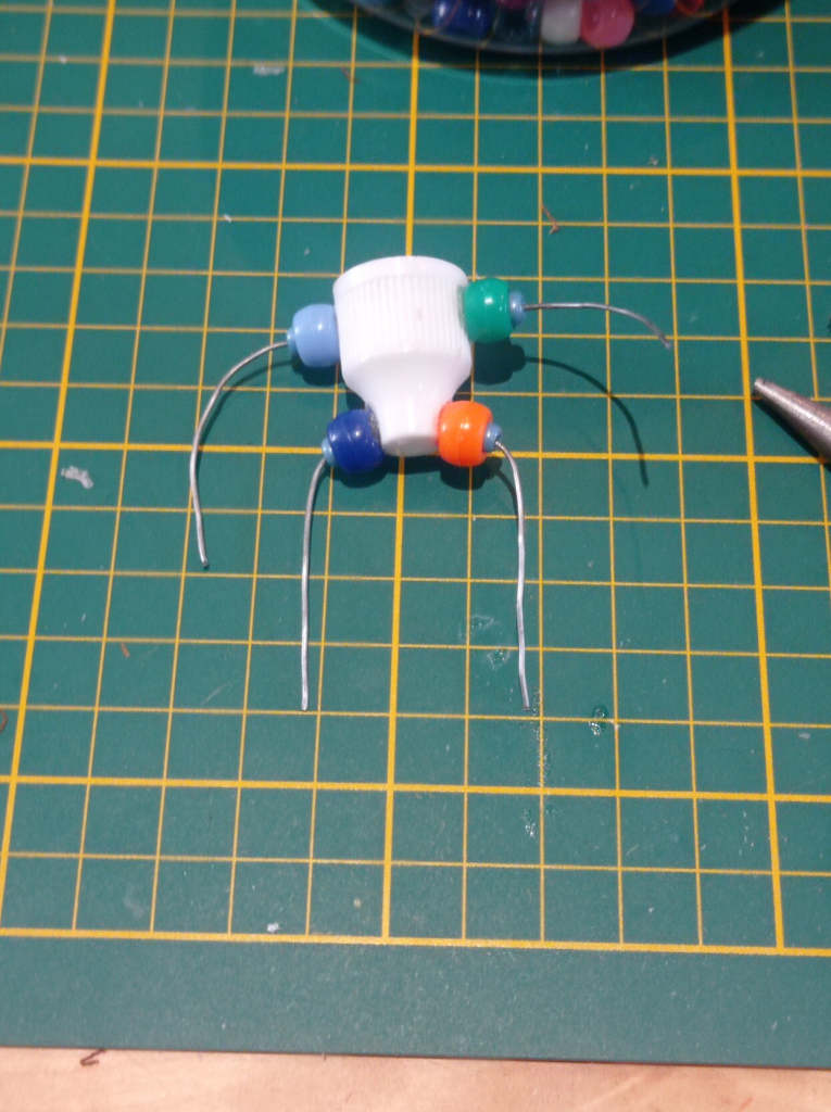 The beads are strung on the wire to begin to add thickness to the legs and arms.