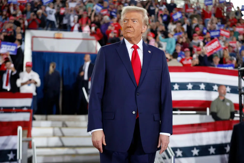 politician walks past the crowd as he arrives to speak at a rally