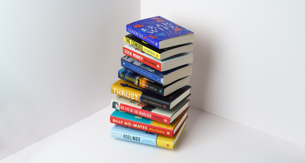 A pile of some of the books we publish. They are pictured in a corner against a light background seemingly floating off each other. There are 9 books in the pile, hardbacks and papaerbacks, each more desirable than the last.