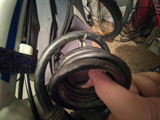 Bike lock with a deep cut into the rubber covering around a steel cable 