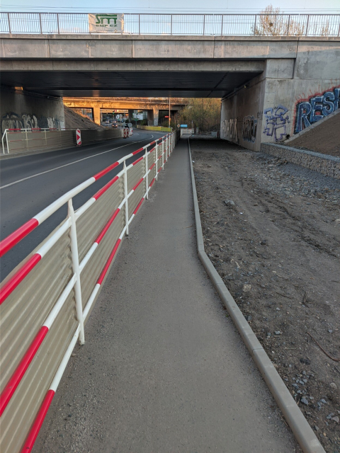 New wide railway bridge, but with new still narrow pavement under it. The pavement is narrower there then in front and behind the bridge.