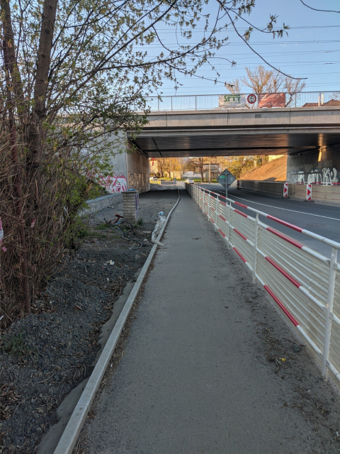 Normal wide pavement gets very narrow under the wide bridge