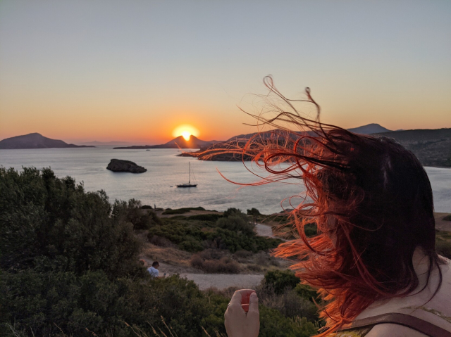 Anna watching the sunset landscape with hair flying in the wind all over the image