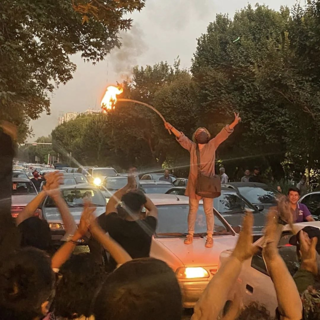 Picture of Iranian woman burning her hijab