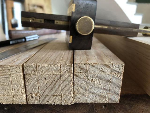 Las columnas marcadas para cortar espigas de 20mm, con el gramil al fondo.