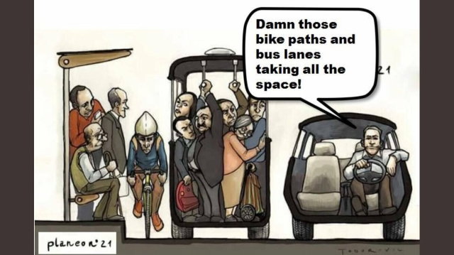 A cartoon showing a transversal cut of road users. Furthest to the left some people crowd in a small bus stop. Next to them a cyclist squeezes through. Next to him a whole bunch of people are crowded together in a bus, squeezed next to each other. In the right side we see a single man comfortably sitting at the wheel of his empty car. He says "Damn those bike paths and bus lanes taking all the space!"