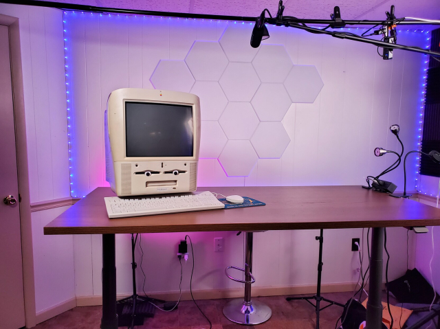 A G3 Macintosh all in one sitting on a powered IKEA standing desk. It's a heck of a beige chonker with built in CRT