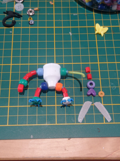 More beads are threaded on the wires to finalize the legs and arms 