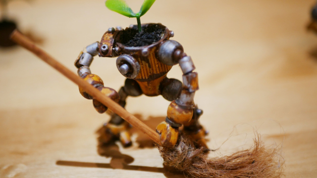 Another robot sweeping, he was painted to give a rusty effect. A plant is growing on his head.