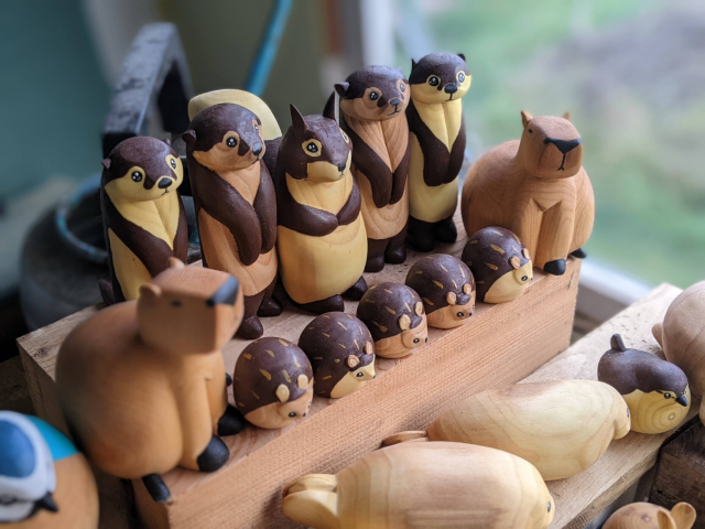 Détail des rangées du haut, au premier plan un capybara flou, 5 hérissons et 1 capybara flou. Au deuxième rang, 2 loutres, 1 écureuil, puis deux loutres.