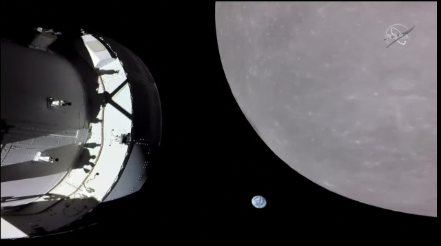 The Orion spaceship flies around the moon, between them the earth is visible. It looks like a small blue marble with streaks on it, floating amongst the enormous moon and the satellite in the foreground. 