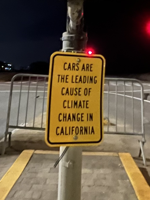 A street sign that says “cars are the leading cause of climate change in California”
