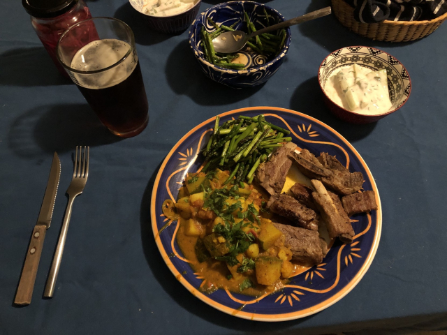 Costilla de cerdo frita a la naranja, curry de chayotes y papas, espárragos salteados con ajo, raita de pepino, cerveza.