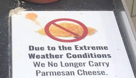 A sign that says "Due to the Extreme Weather Conditions We Ne Longer Carry Parmesan Cheese."