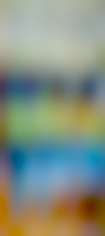 A multi-coloured striped blanket on a bed, with various bits of furniture in the background. The colours of the blanket represent the high and low temperatures experienced in Aberystwyth in 2022. 