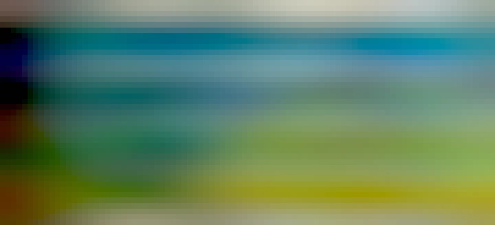 Half of a  multi-coloured striped blanket on a bed, with various bits of furniture in the background. The colours of the blanket represent the high and low temperatures experienced in Aberystwyth in 2022. This shows January to June.