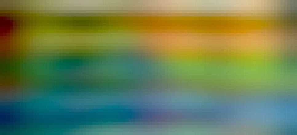 Half of a  multi-coloured striped blanket on a bed, with various bits of furniture in the background. The colours of the blanket represent the high and low temperatures experienced in Aberystwyth in 2022. This shows July to December.