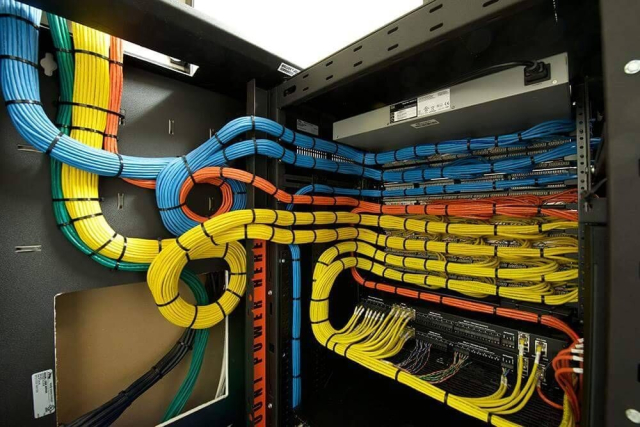 A gorgeous display of cable management. The cable intake is on the upper left and the server is to the right. The cables drop in, in organized bundles. Blue, green, yellow, and orange. The neat cables and tied together with their respective color. The green color wraps near the yellow, but sinks to the floor. The blue is the largest section, and makes a cute lil loop around the orange cables before seating into the top three servers. The orange is in the middle surrounding the yellow, and the yellow is the majority of the middle section. 
The organized cables bounded together almost look like a water park slide. It's organized, beautiful, and satisfying. 
The cables appreciate you. 