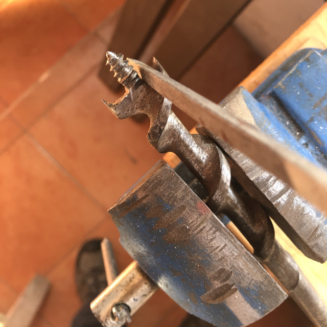 Afilando la parte central de la broca helicoidal con una lima triangular, teniendo cuidado de no lastimar los espolones.
