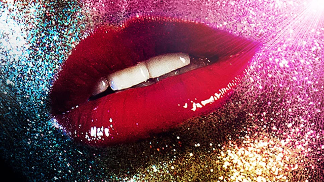 Close-up of glossy red lips and a face covered in glitter.