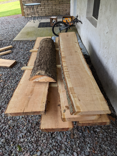 A stack of live-edge slabs of wood from a cherry tree showing their beautiful wood grain.