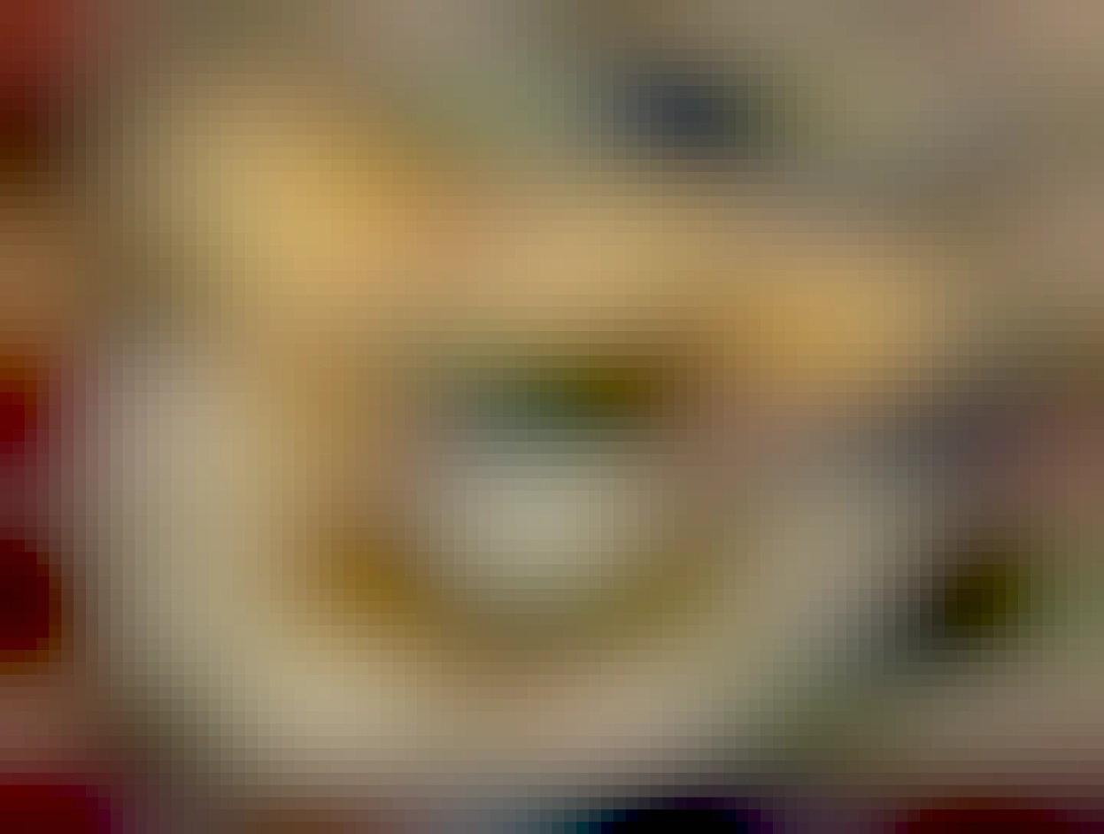 Shredded chicken in soup with corn and beans, garnished with sour cream, cilantro, and corn chips