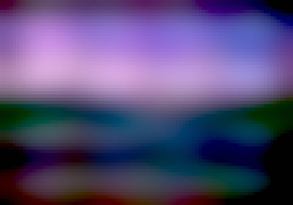 Screenshot of the Loupe image viewer. Navigation and zoom controls are shown across the bottom. The picture displayed is of distant mountains with a city to the bottom right, with a blue and purple sky.
