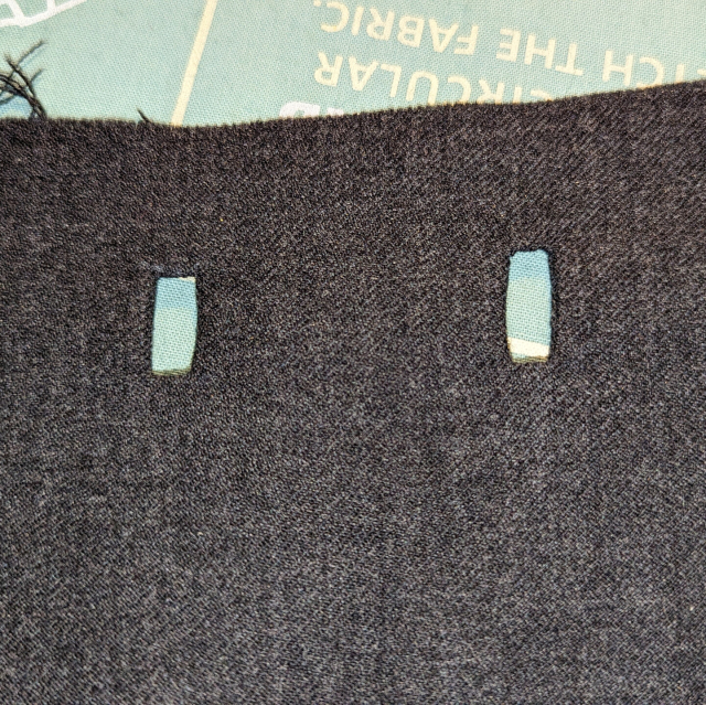 Close up shot of the exterior of two lined button holes on the front of a waistcoat piece.