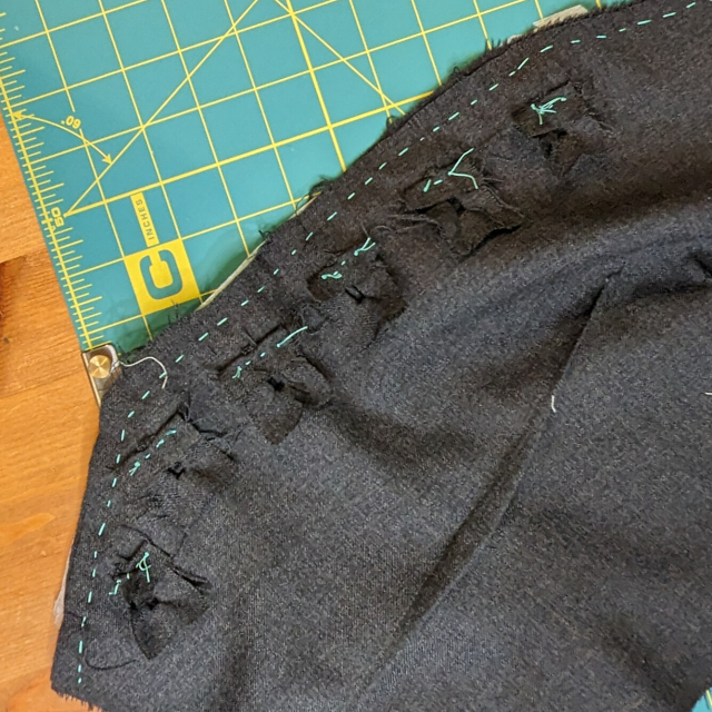Button holes with their lining fabric carefully tacked out of the way of the seam line 