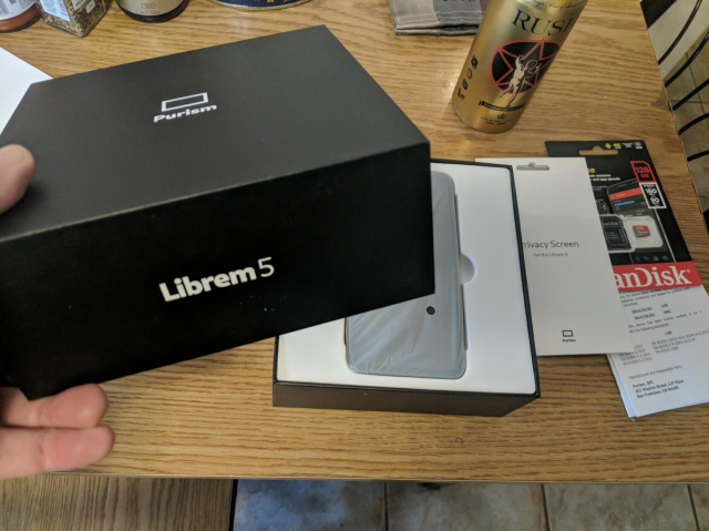 Unboxing the Librem 5 - pulling off the nice minimalist black box top that reads "Purism" and "Librem 5"