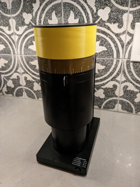 Fellow Opus coffee grinder with a yellow 3 inch tubular extension on the top.