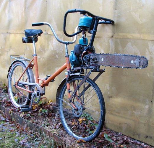 Vieux vélo de ville pliant orange avec une tronçonneuse installée sur le porte bagages avant , lame pointée vers l'avant et connectée à la roue avant 