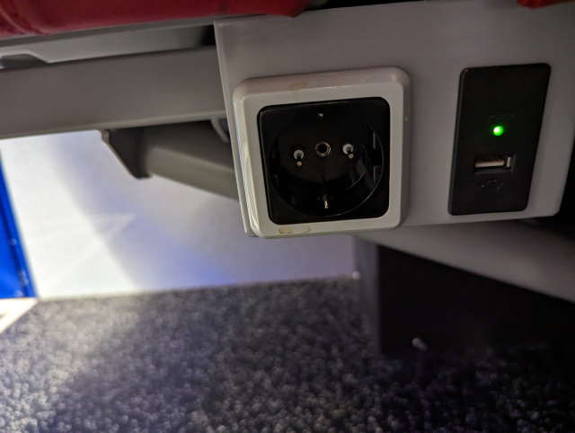 An under seat socket of a SNG train. The Schuko socket has metal conductors plugged into the holes exposing 230 V to anyone trying to blindly plug in a charger.