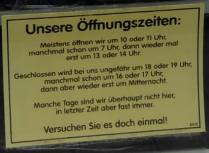 Schild an der Ladentür mit dem Titel "Unsere Öffnungszeiten" – gefolgt vom Text:

"Meistens öffnen wir um 10 oder 11 Uhr, manchmal schon um 7 Uhr, dann wieder mal erst um 13 oder 14 Uhr.

Geschlossen wird bei uns ungefähr um 18 oder 19 Uhr, manchmal schon um 16 oder 17 Uhr, dann aber wieder erst um Mitternacht.

Manche Tage sind wir überhaupt nicht hier, in letzter Zeit aber fast immer.

Versuchen Sie es doch einmal!
