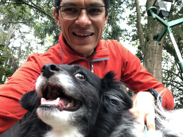 Mozzarello, mi perro blanco y negro, muy sonriente enfrente de mí en el parque. 