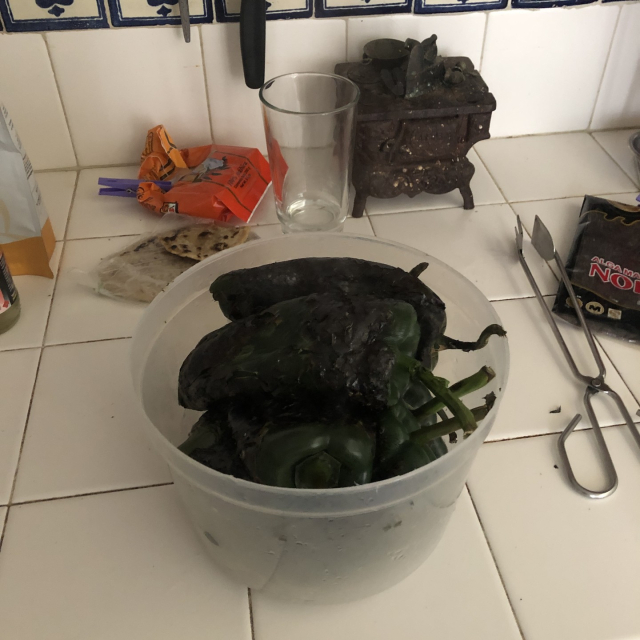 Los chiles ya tostados en un recipiente de plástico.
