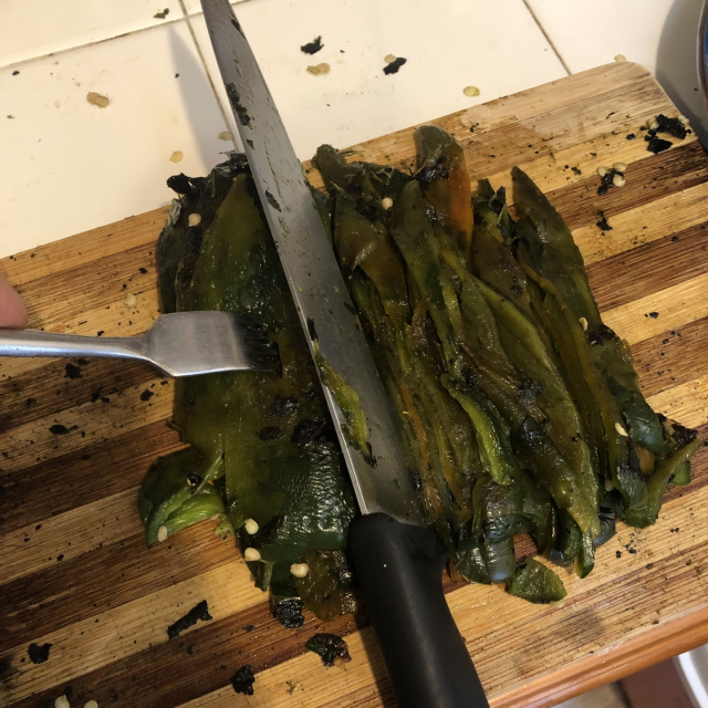 Cortando varias capas de chiles en rajas.