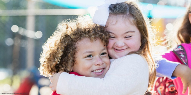 Young girl with down's syndrome hugging another girl