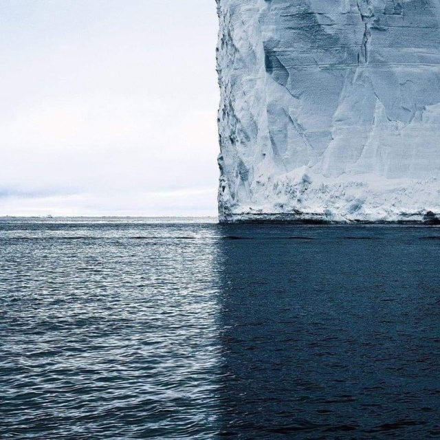 Photo of an iceberg in mid ocean, divided into four almost-equal squares. 
Top left: sky,  whitish blue
Top  right: Iceberg, light blue
Bottom left: ocean, mid blue
Bottom right: ocean shaded by the iceberg, dark blue