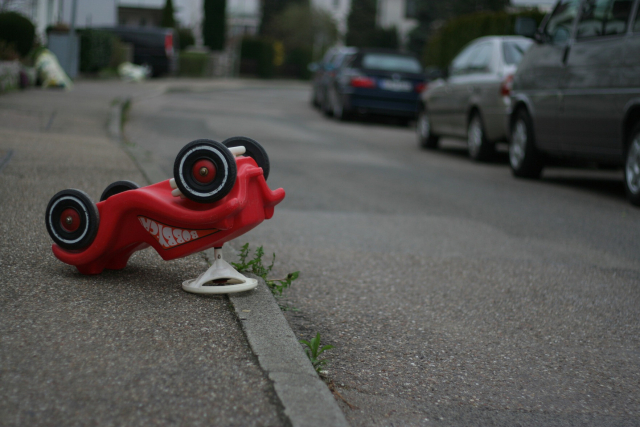 a toy car lies upside down as after a crash