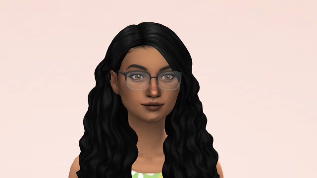 Close up screenshot of a brown-skinned woman with wavy black hair, hazel eyes, black glasses, and a scar on the bottom of her cheek.