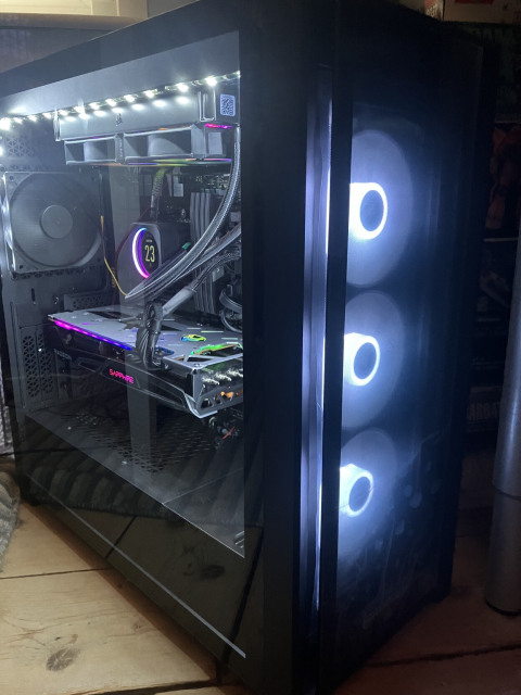 A three quarters view of a powered up desktop, with three fans lit up in white in the front of the case