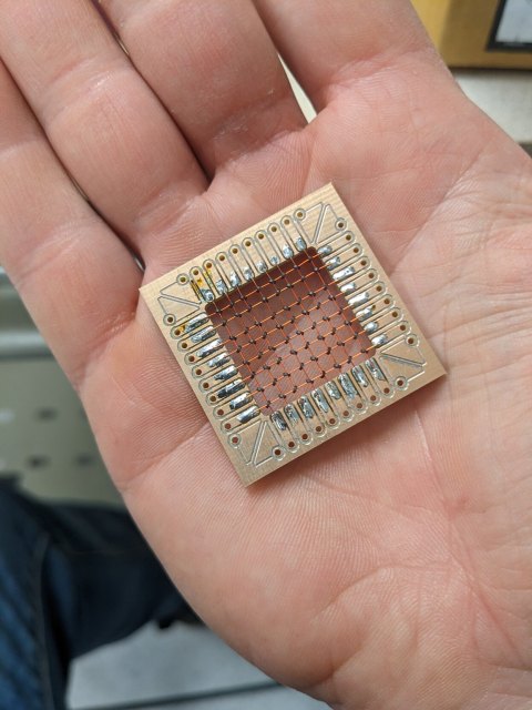 Copper board with center cut out and filled with crossed wires that have toroids on the intersections.