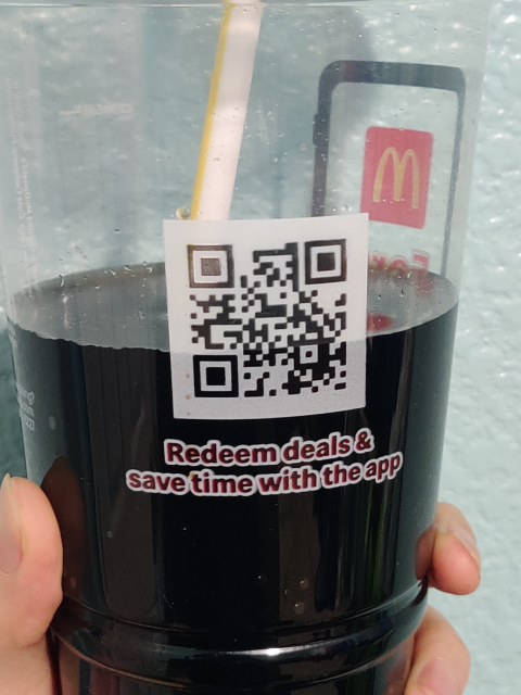 a version 2M qr code on the side of a mcdonald's drink cup. the qr code itself is a square that is basically made up of black and white pixels in a 25x25 grid that encodes information like the barcode orientation, size, error correction level, the data of the code itself, and some extra data to be able to detect and recover from failures to read the code properly

this qr code also happens to have the 4 module wide quiet zone around it which is required in the specification but that many companies omit from their qr codes
