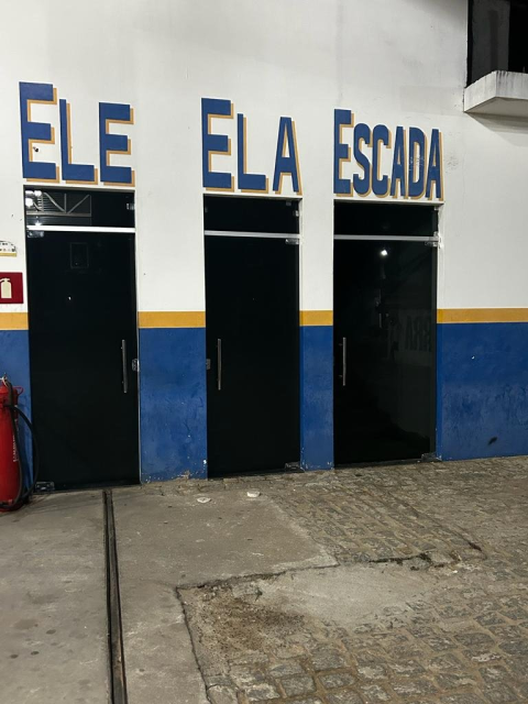 Wall with three doors, tagged (in Portuguese) He, She, Stairs
