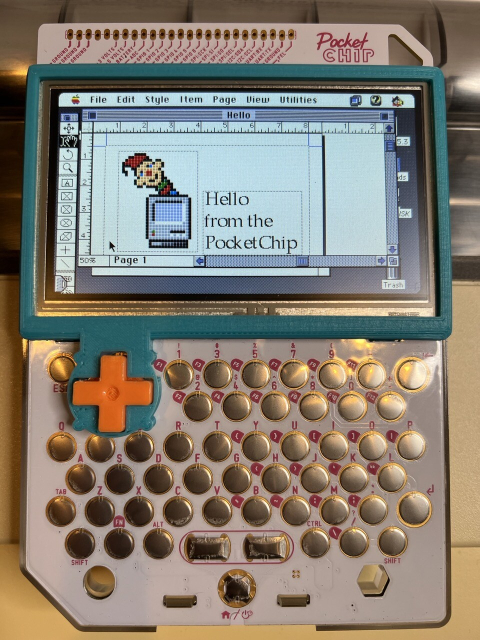 A closeup of the PocketChip showing a document in Quark XPress using the Mini VMac emulator sitting on top of an ImageWriter II printer. The document on the screen says Hello from the PocketChip with a picture of the ResEdit icon.