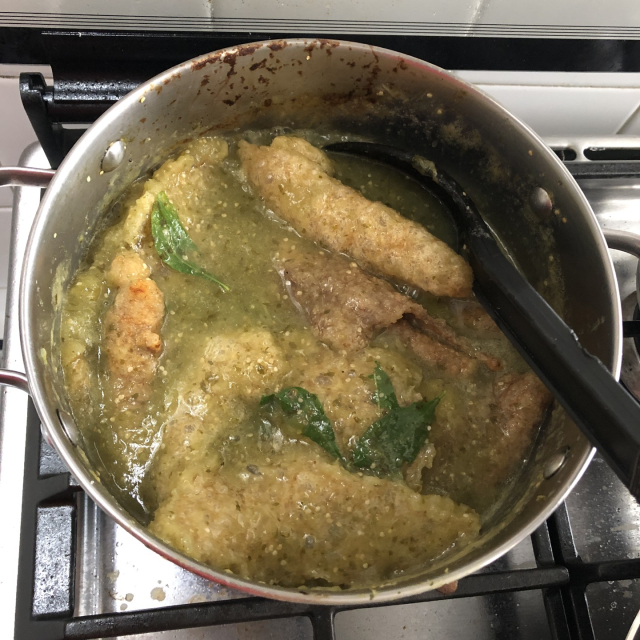 Una olla con chicharrón en salsa verde y epazote.