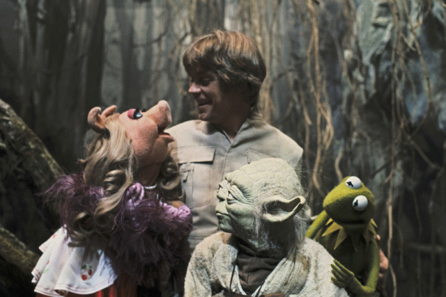 Color image of Miss Piggy and Luke Skywalker looking at each other, while Yoda is turned left staring at them and Kermit the frog is turned staring at Yoda.