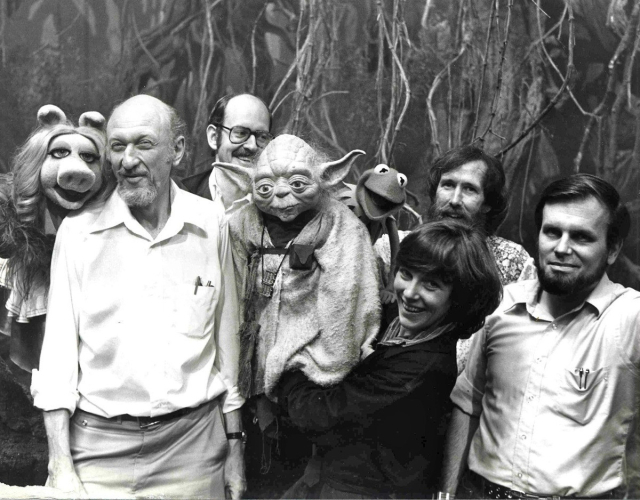 Black and white picture of Miss Piggy with Irvin Kershner, Frank Oz in background, and Jim Henson with Kermit the frog.
